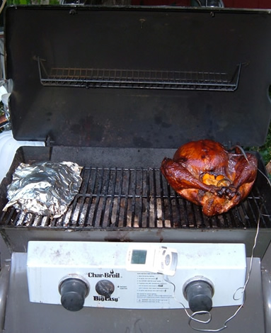 full view of turkey and foil pack and grill